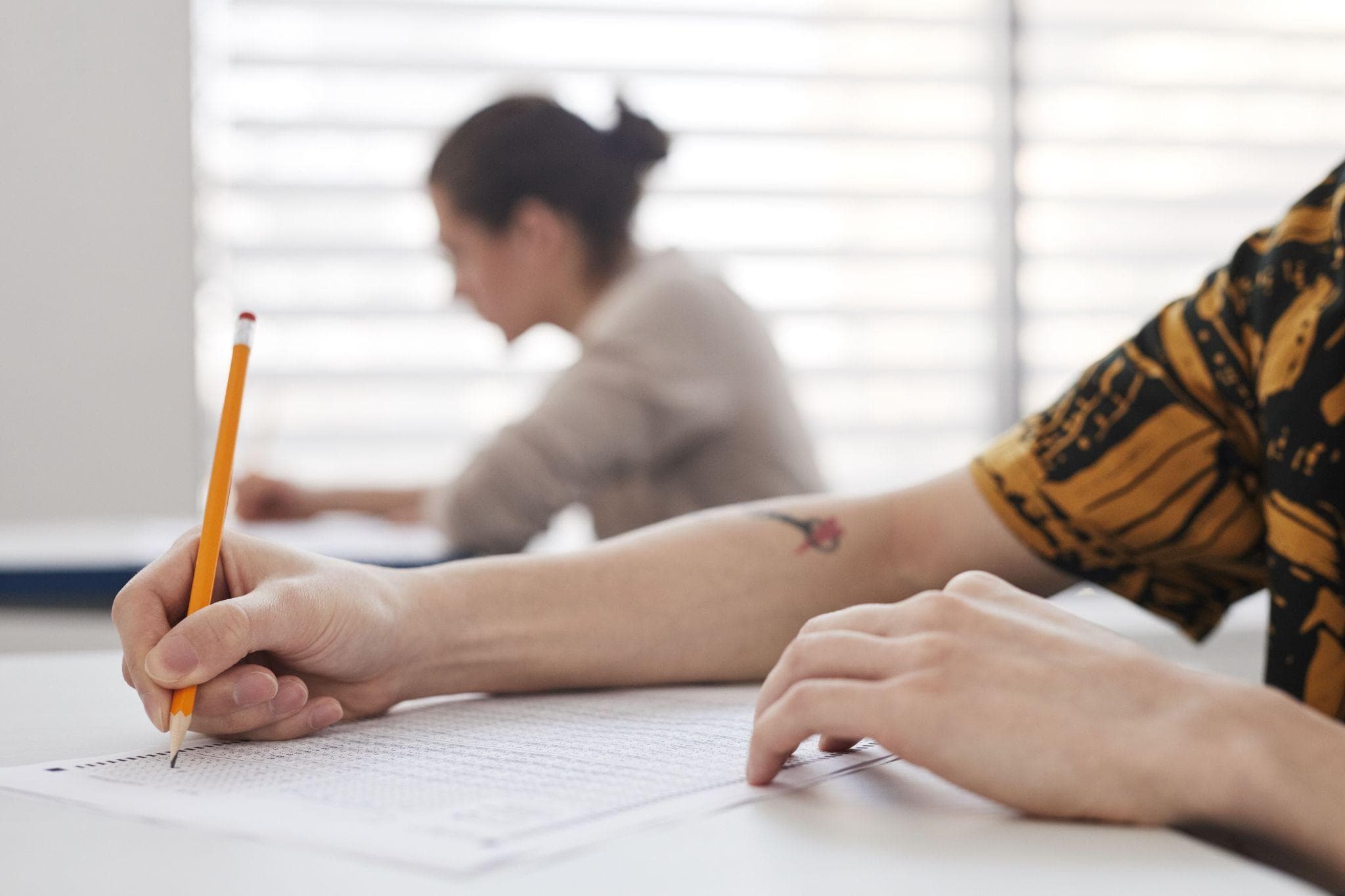 Estudiantes rindiendo un examen escrito en el aula